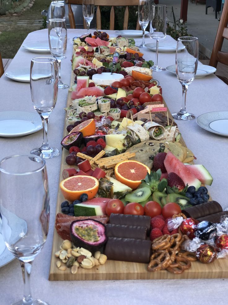 a long table with many different types of food and wine glasses on top of it