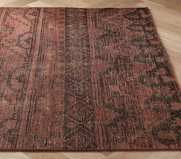 an old rug is laying on the floor in front of a wood flooring area