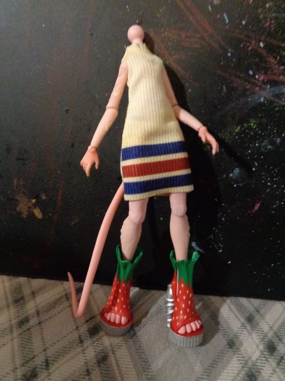 the doll is wearing red, white and blue shoes with green boots on her feet