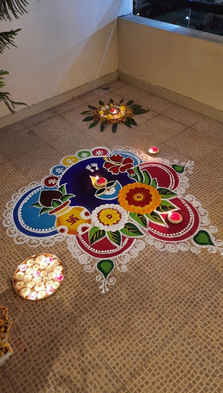 a decorated floor in the middle of a room with candles and plates on the ground