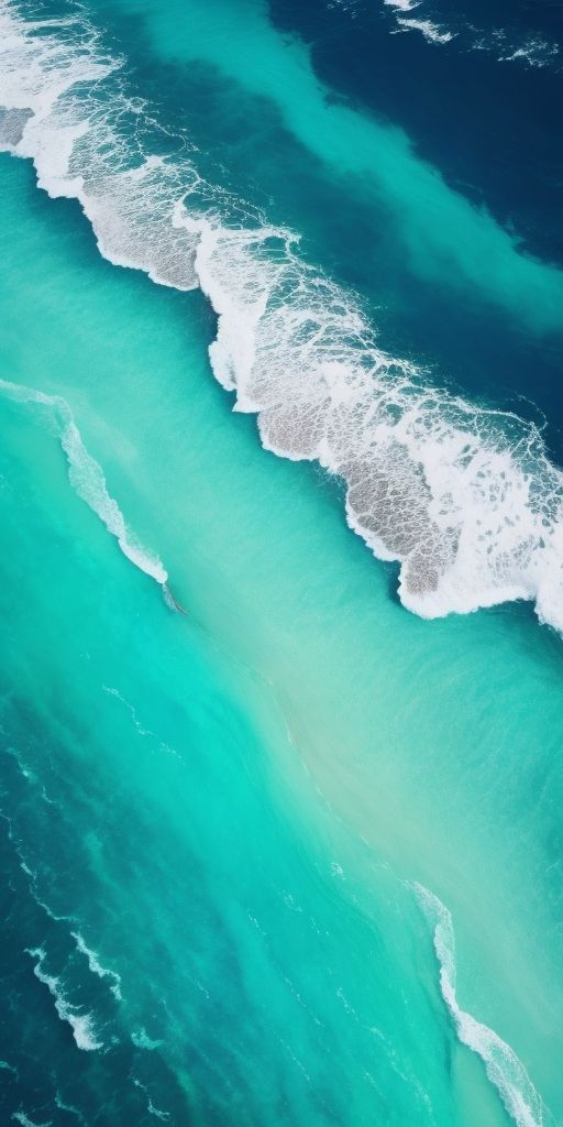 an aerial view of the ocean with waves coming in from the shore and blue water