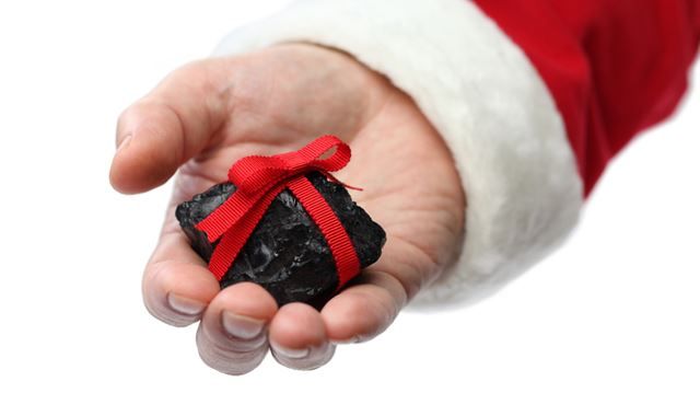 a hand holding a rock with a red ribbon on it