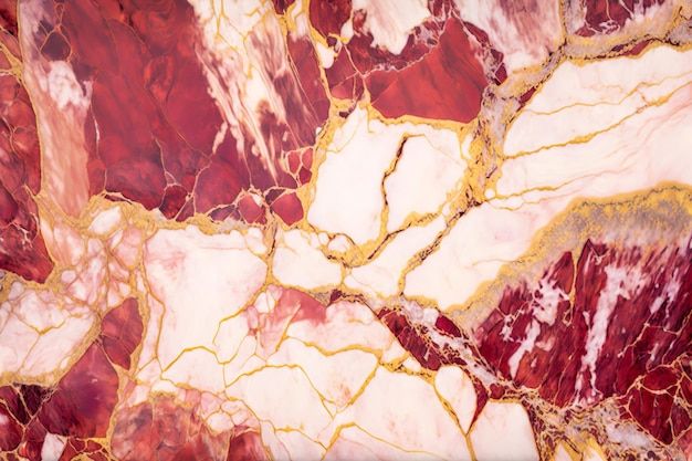 an abstract marble pattern with gold and red colors on the surface is seen in this image