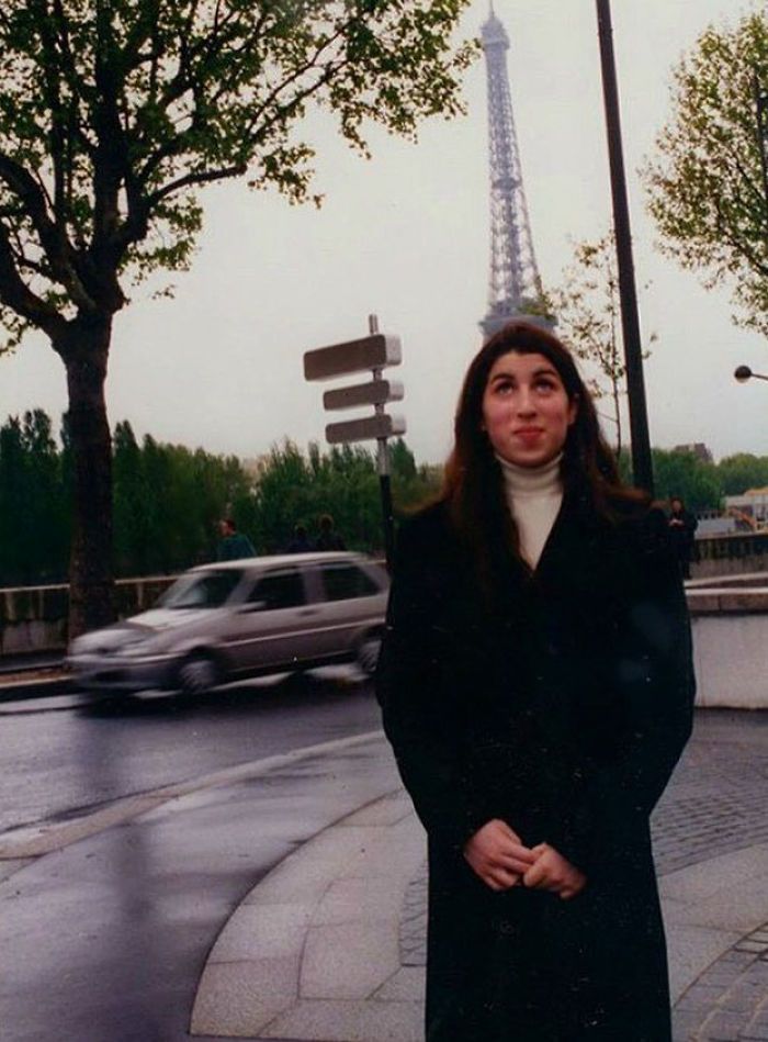 a woman standing in front of the eiffel tower