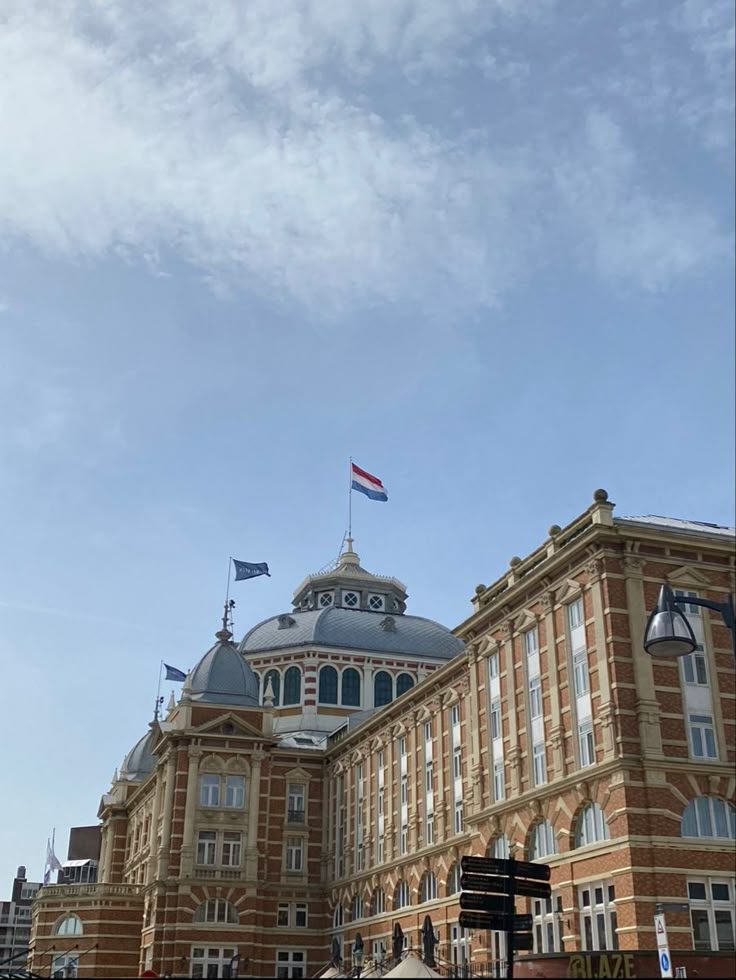 an old building with flags flying in the wind