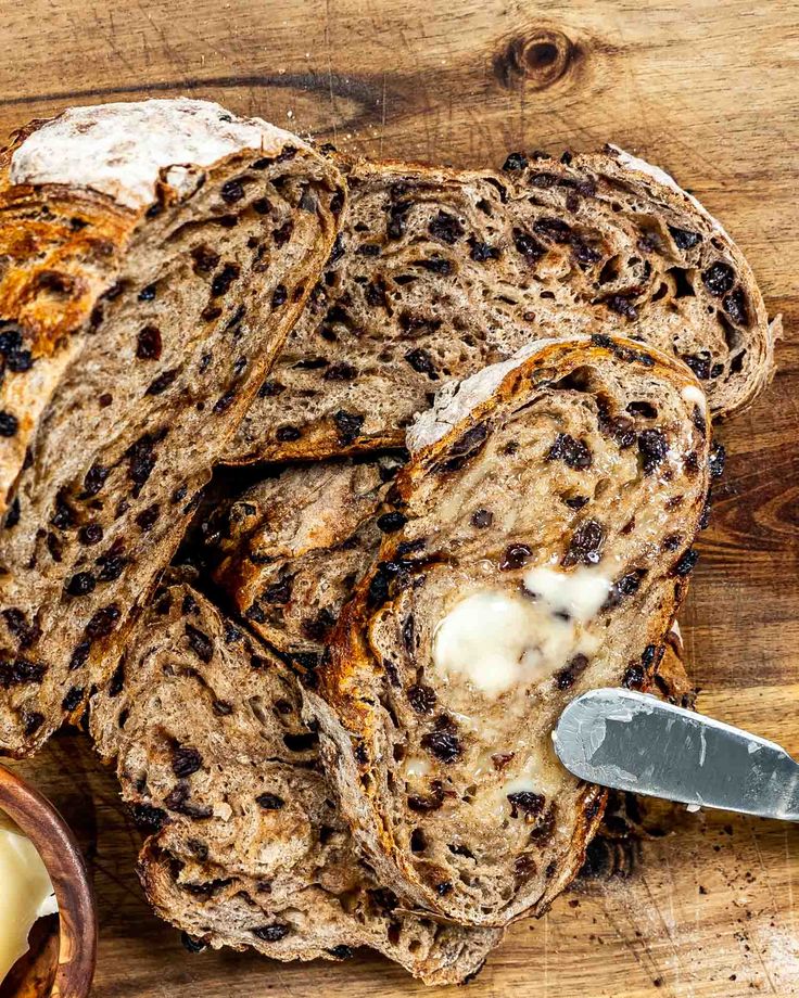 sliced bread with butter and raisins on a cutting board