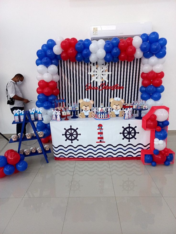 the table is decorated with red, white and blue balloons for an ocean themed party