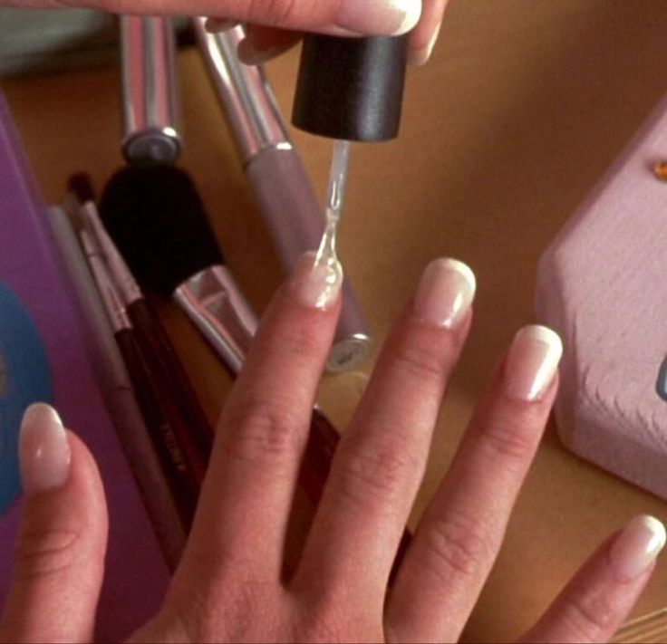 a woman's hands with french manies and nail polish