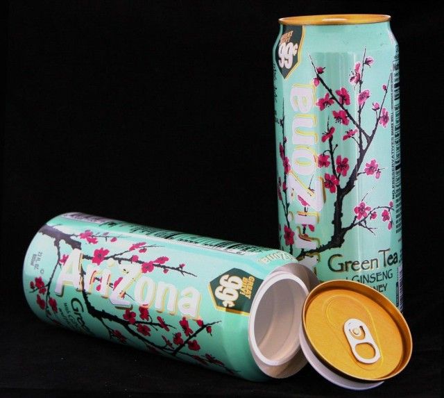 two cans of green tea with pink flowers on them and one has an orange cap