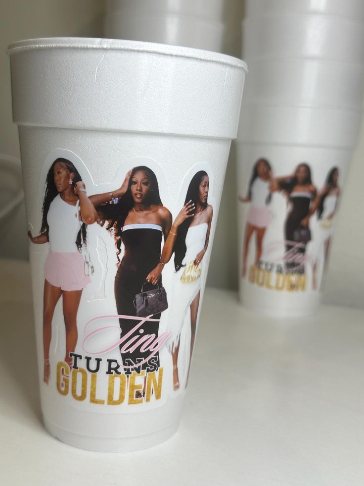 two cups with pictures of women on them, one is white and the other has gold