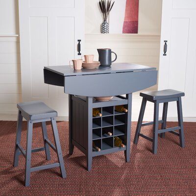 a small kitchen table with two stools and a wine rack in the center on carpeted flooring