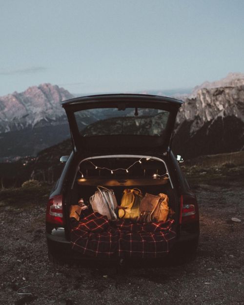 the back end of a car with its trunk open and luggage in it's trunk