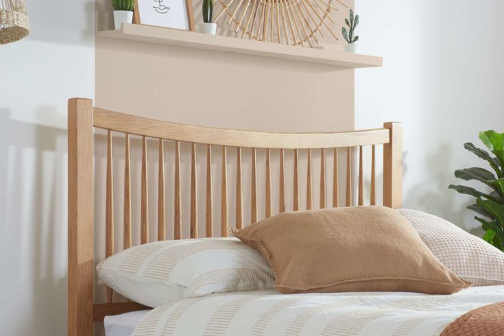 a wooden headboard with pillows on top of it in front of a wall mounted clock