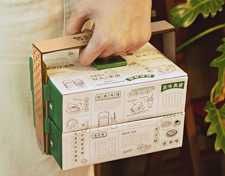 a person holding a green box with instructions on it