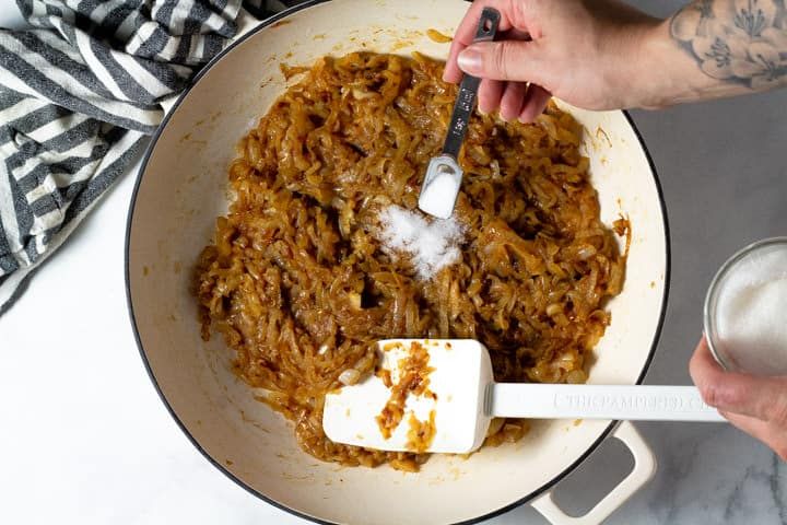 a person mixing food in a pan with a spatula next to a glass of milk