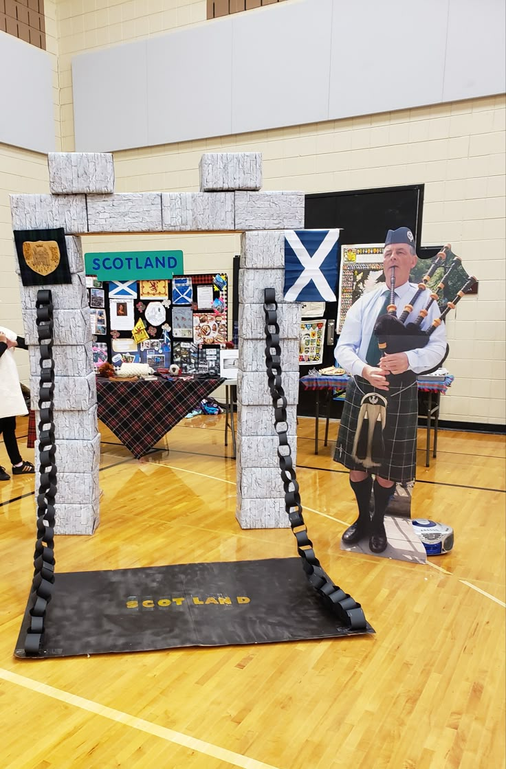 a man in kilts playing bagpipes on a wooden floor next to an arch made out of blocks