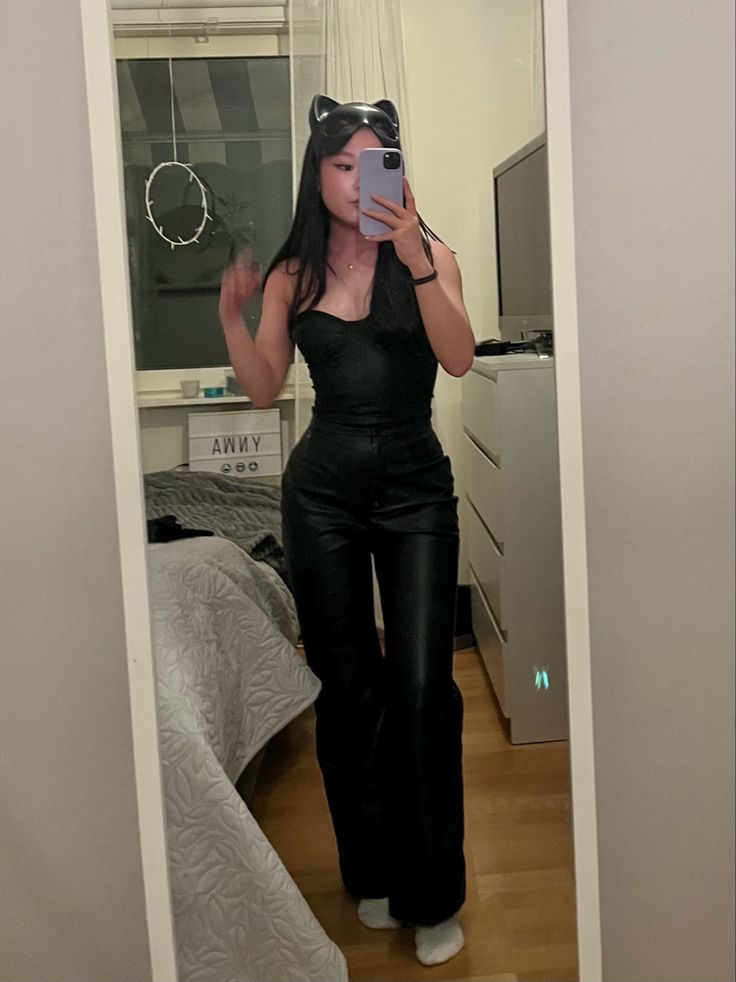 a woman taking a selfie in the mirror with her phone and cat ears on