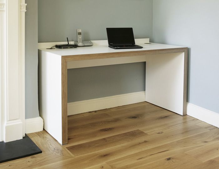 a laptop computer sitting on top of a wooden desk next to a white fireplace mantel