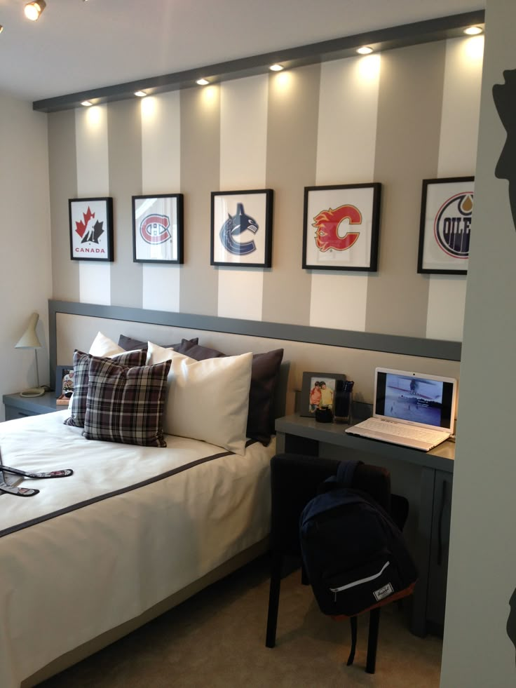 a bedroom with a bed, desk and pictures on the wall above it's headboard