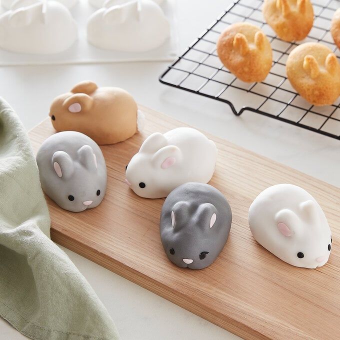 five small plastic mice sitting on top of a wooden board next to donuts and other pastries