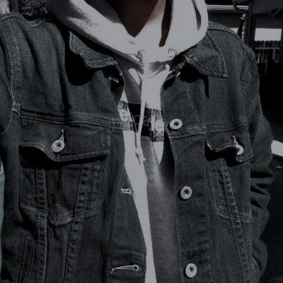 a man wearing a denim jacket and hoodie