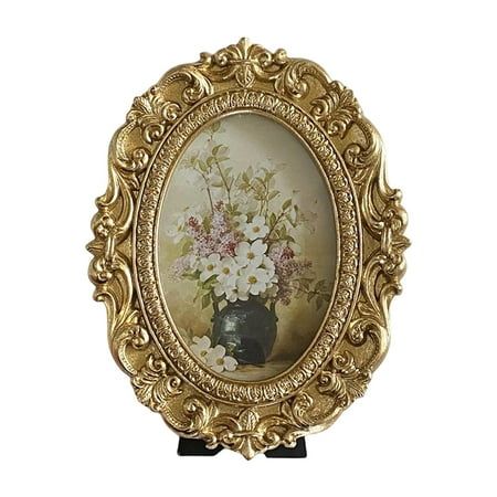 an ornate gold frame holds a painting of flowers in a black vase on a white background