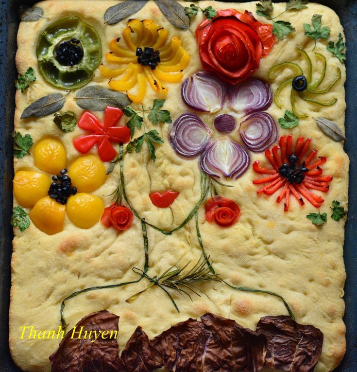 a pizza decorated with flowers and vegetables on it