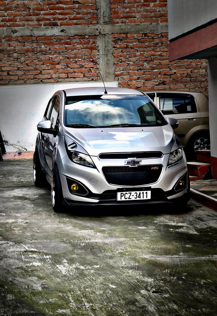 a silver car parked in front of a brick building