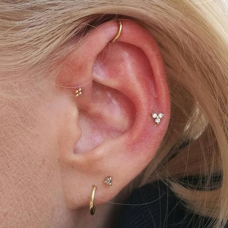 a close up of a person's ear with three small diamond studs on it