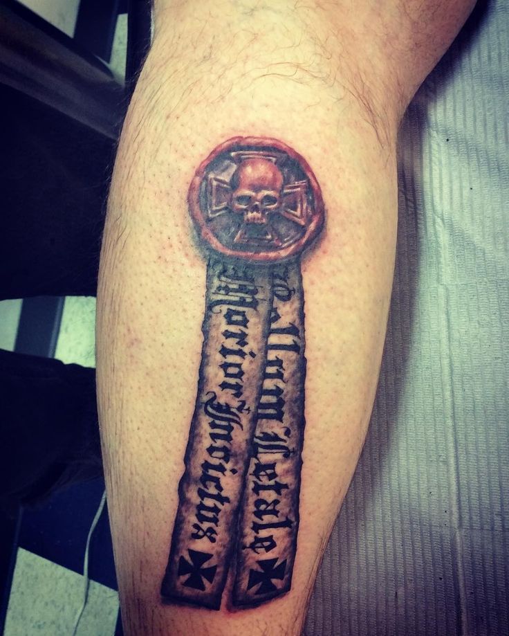 a man with a tattoo on his leg that has a key and skull in it