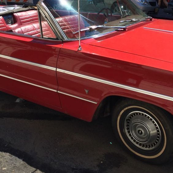 a red convertible car parked in a parking lot