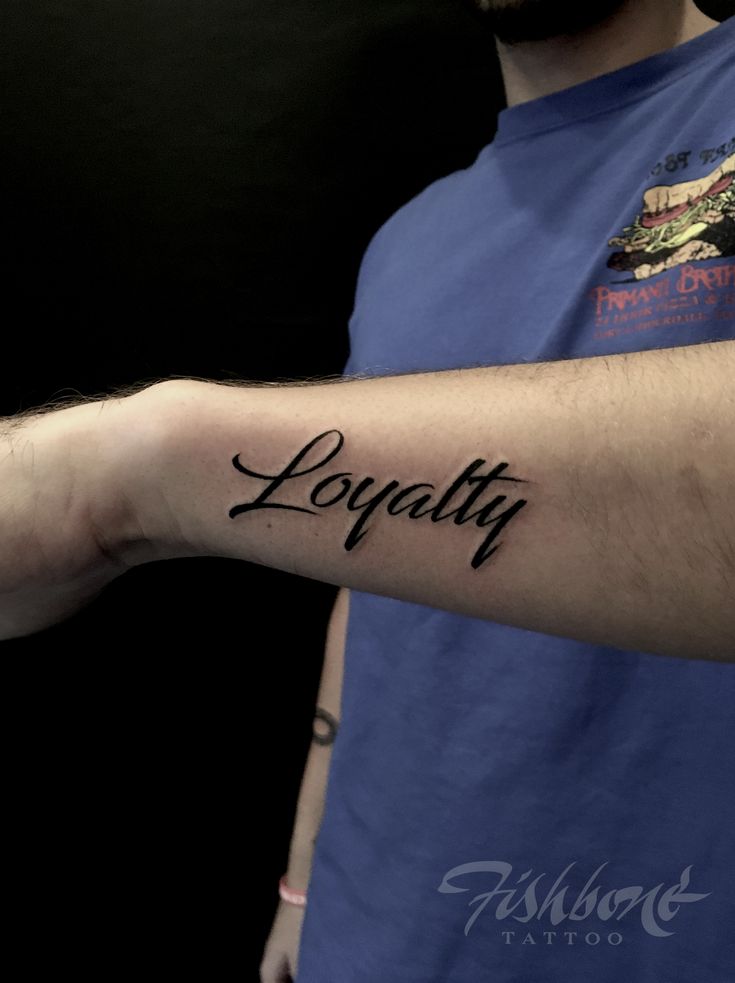 a man with a tattoo on his arm that says loquatiy in cursive writing