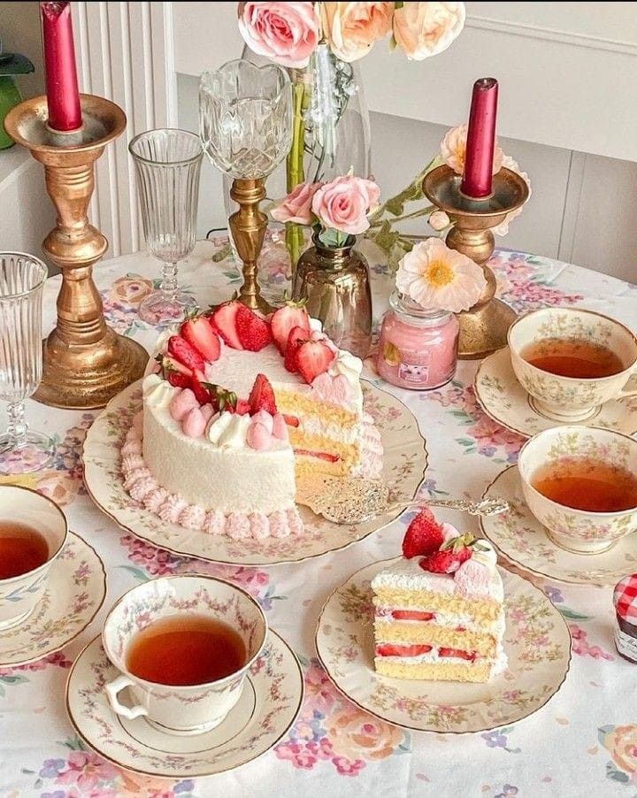 a table topped with cakes and cups of tea