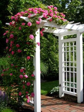 a white arbor with pink flowers on it