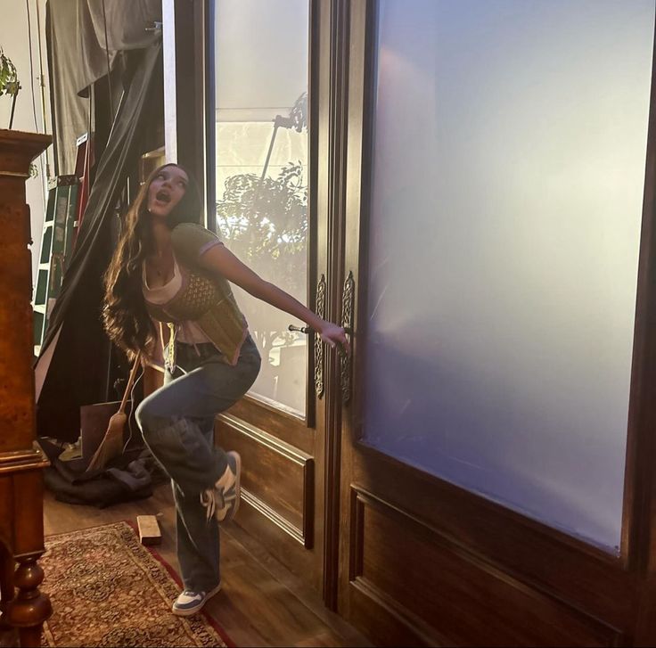 a woman jumping up into the air in front of a door