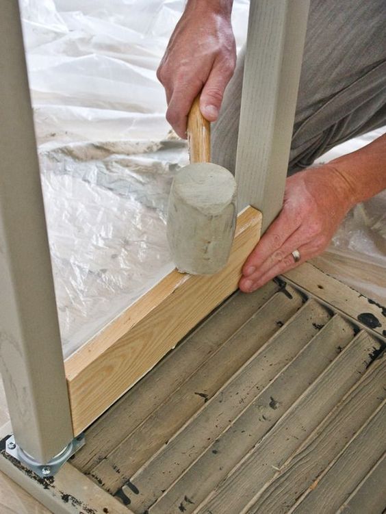 a man is working on some wood with a hammer