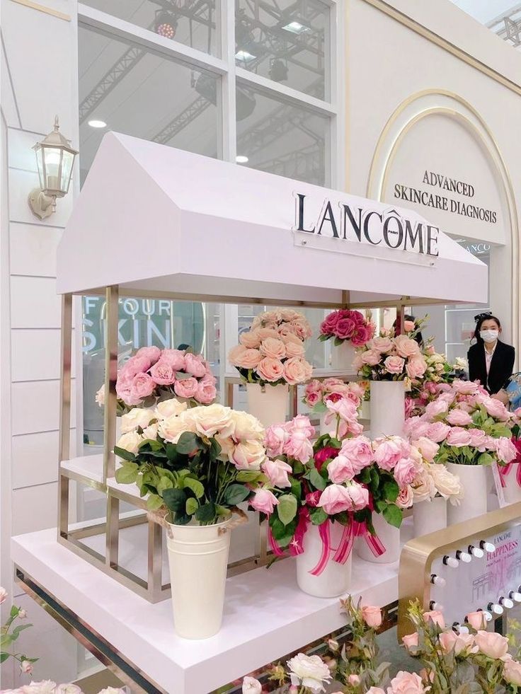 a bunch of flowers are on display at a flower shop in front of a sign that says lancomme