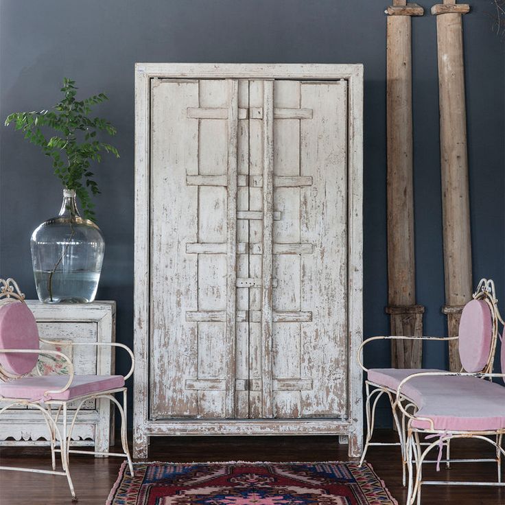 a room with two chairs, a table and a large white door in it's center