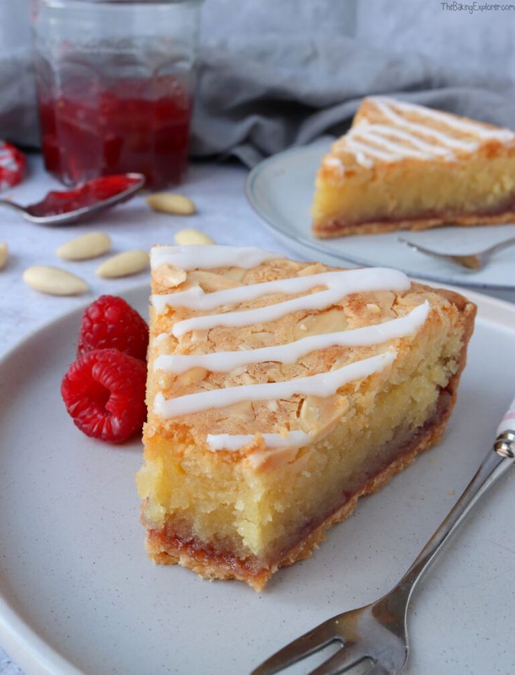 a piece of cake sitting on top of a white plate next to a raspberry