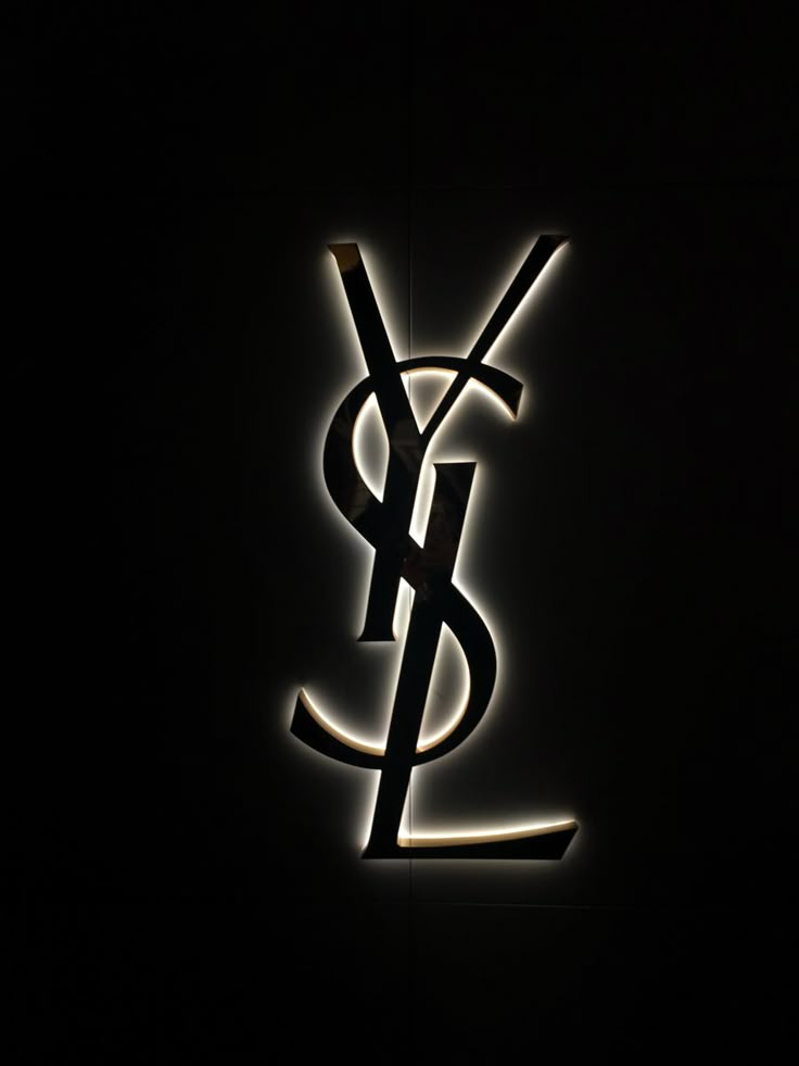 a black and white photo of the y logo on a dark wall with light coming from it