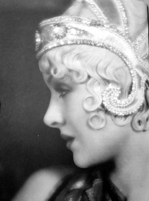 an old black and white photo of a woman wearing a tiara