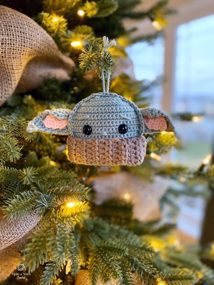 a crocheted ornament is hanging on a christmas tree