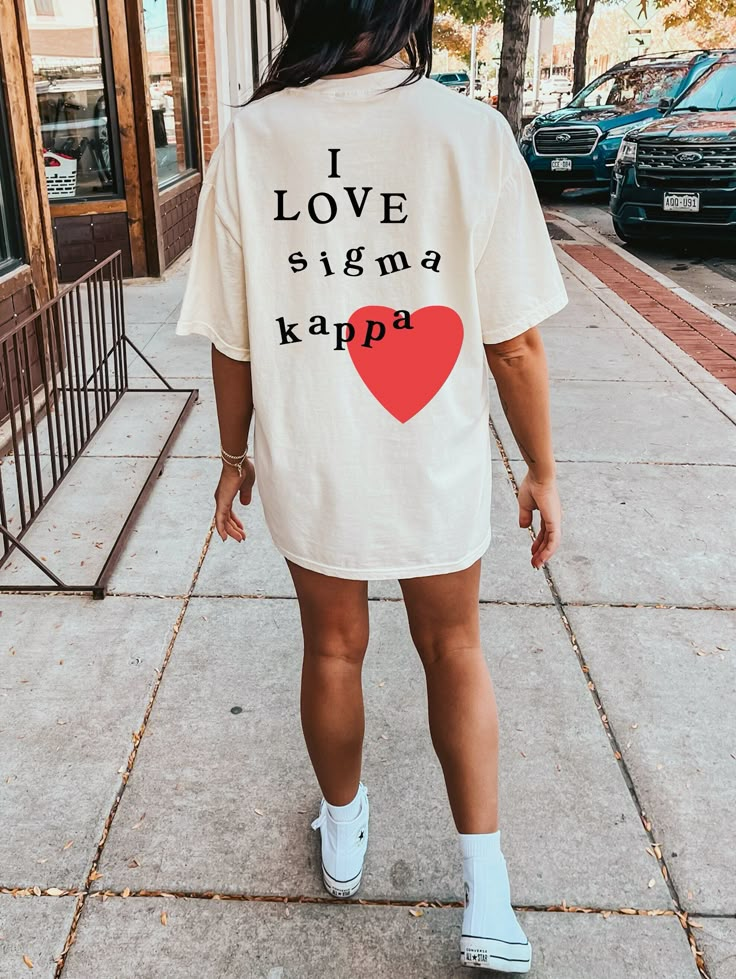 Soft, cute, and trendy, this Sigma Kappa sorority t-shirt will quickly become your go-to cozy shirt! Use the drop down to specify preference between white, ivory, island reef, chambray, orchid, or blossom. Printed with black color letters and red color heart.  LISTING IS FOR SIGMA KAPPA. Please be sure you are ordering for your correct Sorority. We print on high quality, soft, & heavyweight materials, sustainably made and printed in the US. ♥ SIZING ♥ Unisex Sizing- For a more feminine, fitted look we recommend getting your size. For a more oversized look, we recommend sizing up. ♥ SHIP TIME ♥ Items may take up to 7 business days to process before shipping. Shipping time is (on average) an ADDITIONAL 2-5 business days. Shipping times vary for many reasons, but is largely influenced by your Alpha Chi Omega Merch, Alpha Delta Pi Sorority, Delta Gamma Sorority, Alpha Phi Sorority, Big Little Sorority, Alpha Epsilon Phi, Theta Phi Alpha, Sorority Shirt, Delta Sorority