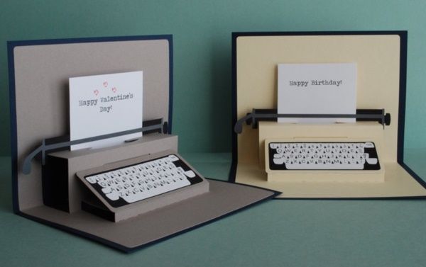 two greeting cards with an old fashioned typewriter in the middle one is open and the other is closed