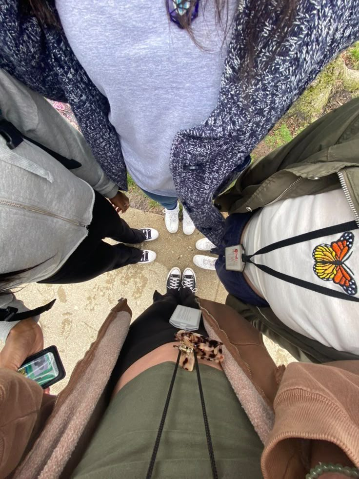 several people standing in a circle looking up at the sky with their feet on the ground