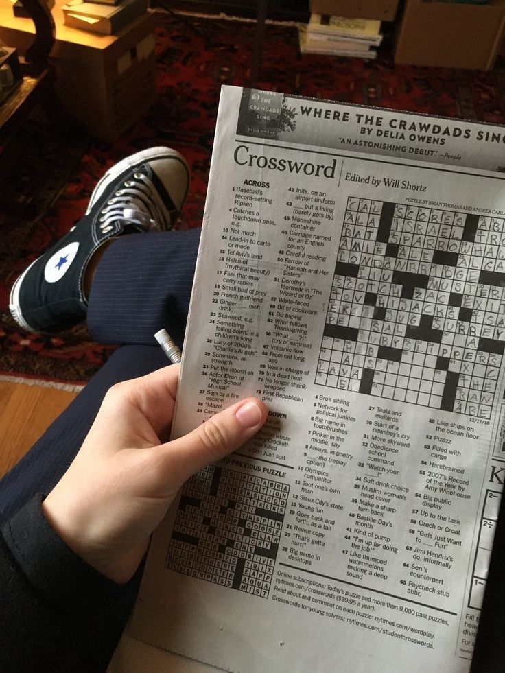 a person is holding up a crossword puzzle