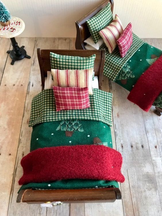 a wooden rocking chair sitting on top of a hard wood floor next to pillows and blankets