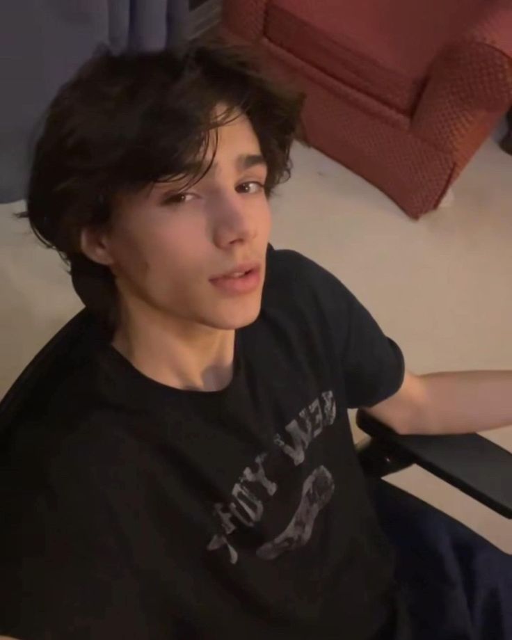 a young man sitting on top of a white couch