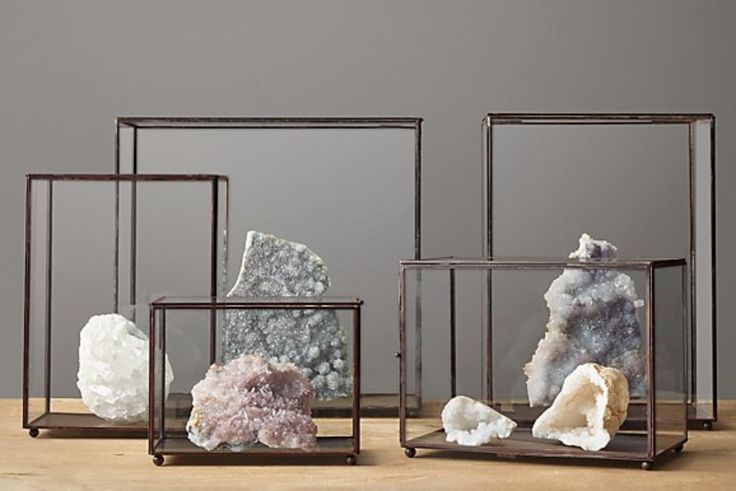 three glass boxes with rocks in them sitting on a wooden table next to each other