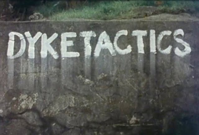 the word dyketactics written in white chalk on a wall